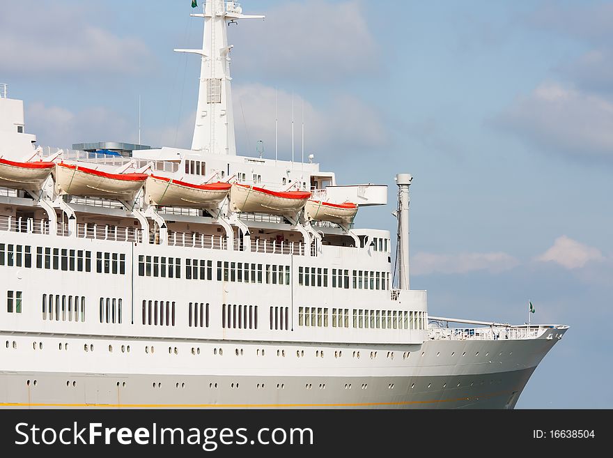 Luxury white cruise ship shot at angle at water level on a clear day with blue sky. Luxury white cruise ship shot at angle at water level on a clear day with blue sky.