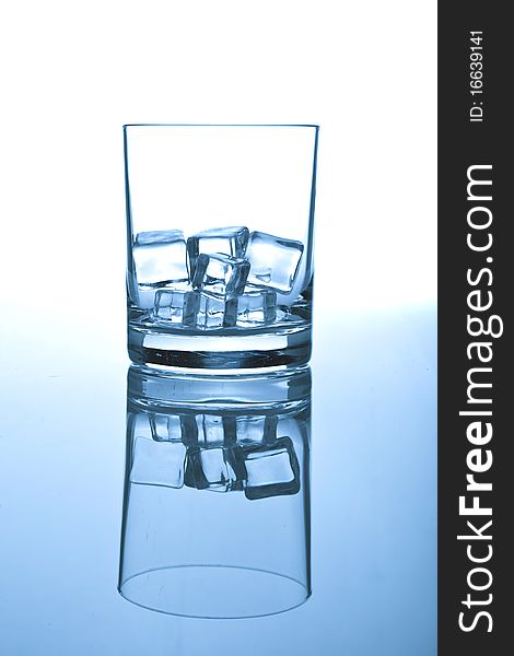 Glass of ice on white-blue background