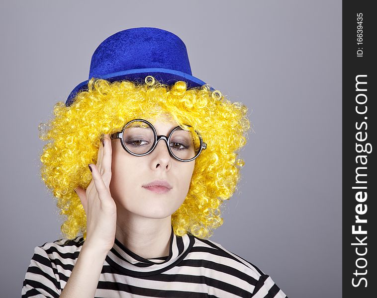 Portrait of yellow-haired girl in blue cap and striped knitted jacket. Studio shot.