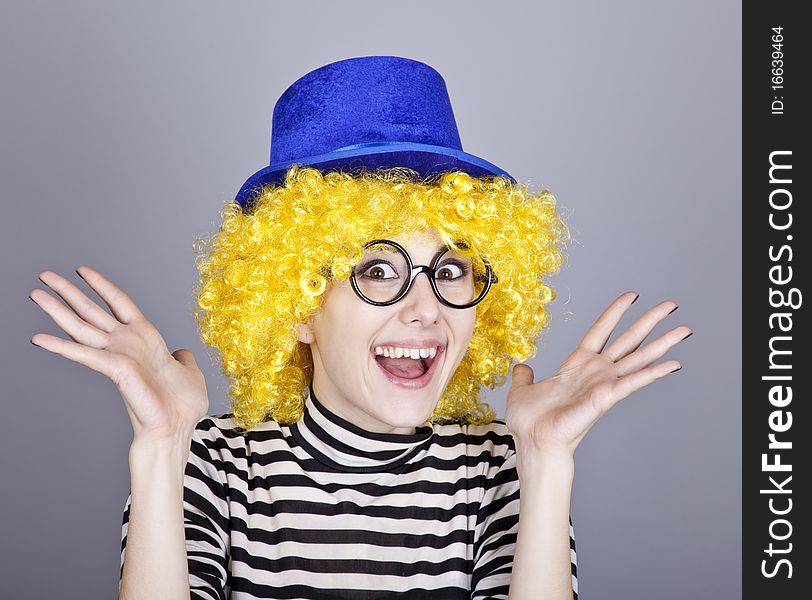 Portrait of happy yellow-haired girl in blue cap and striped knitted jacket. Studio shot.
