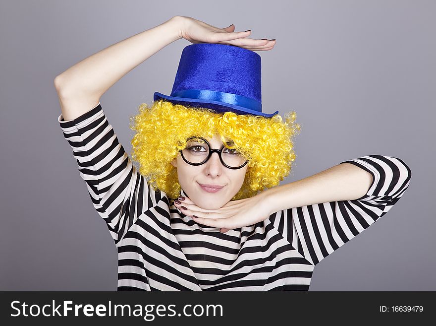 Portrait of yellow-haired girl in blue cap and striped knitted jacket. Studio shot.