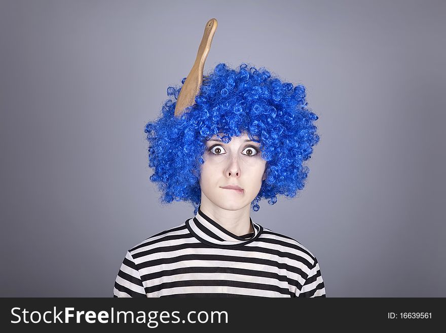 Surprised blue hair girl with stuck comb. Studio shot.