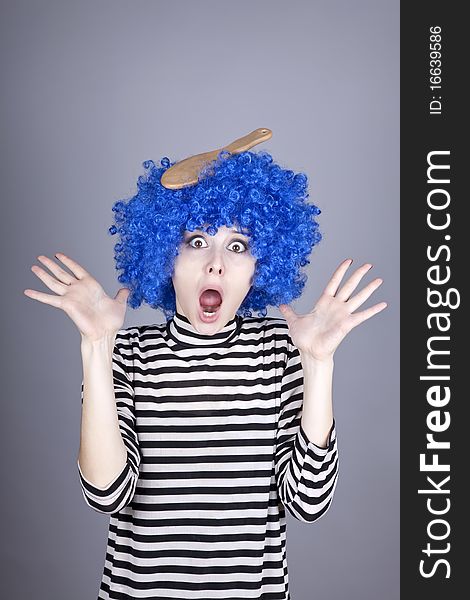 Surprised blue hair girl with stuck comb. Studio shot.