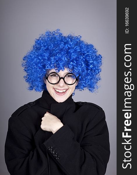 Funny blue-hair girl in glasses and black coat. Studio shot.