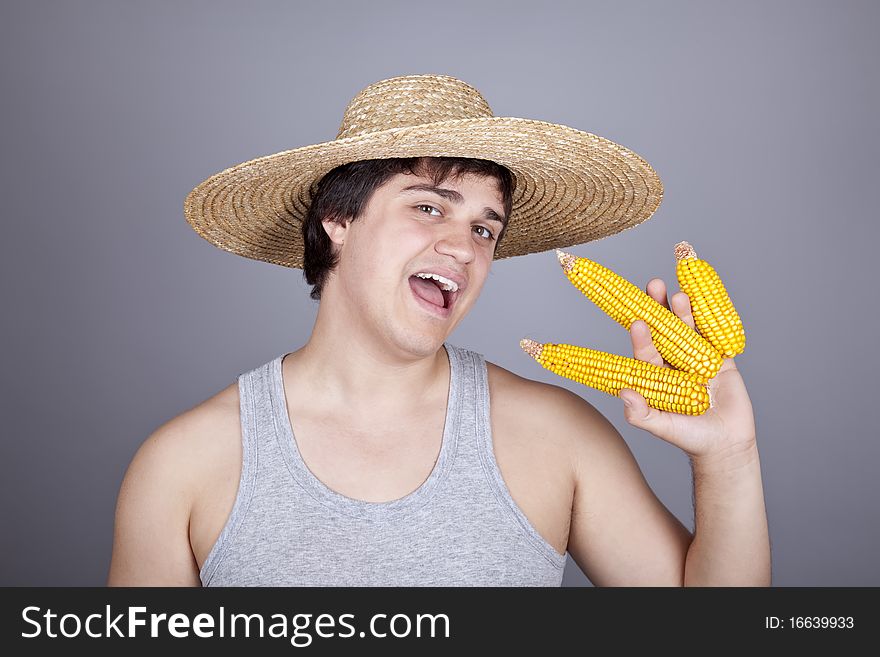 Funny farmer in cap with three corns. Studio shot.