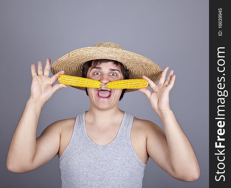 Funny farmer in cap with two corns. Studio shot.