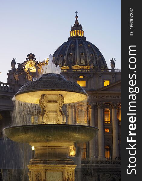 View of the St. Peter`s Basilica from the granite fountain  in the Vatican City, Rome, Italy. The open space which lies before the basilica was redesigned by Gian Lorenzo Bernini from 1656 to 1667, under the direction of Pope Alexander VII. Bernini created a perfect alignment among Maderno`s baroque facade and the oval square surrounded by the massive Doric colonnades,four columns deep, which embrace visitors in `the maternal arms of Mother Church`. The granite fountain was constructed by Bernini in 1675 and matches another fountain designed by Carlo Maderno in 1613. View of the St. Peter`s Basilica from the granite fountain  in the Vatican City, Rome, Italy. The open space which lies before the basilica was redesigned by Gian Lorenzo Bernini from 1656 to 1667, under the direction of Pope Alexander VII. Bernini created a perfect alignment among Maderno`s baroque facade and the oval square surrounded by the massive Doric colonnades,four columns deep, which embrace visitors in `the maternal arms of Mother Church`. The granite fountain was constructed by Bernini in 1675 and matches another fountain designed by Carlo Maderno in 1613.