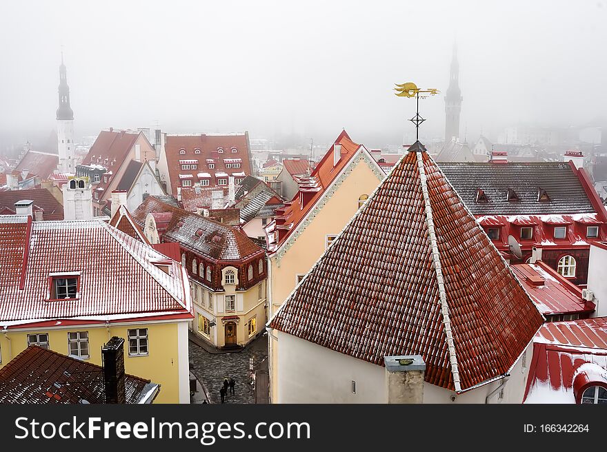 Aerial Cityscape View Of Tallinn Old Town On Winter Day. Red Rooftops From Tiles, Golden Cockerel Weathervane, Town Hall Spire,