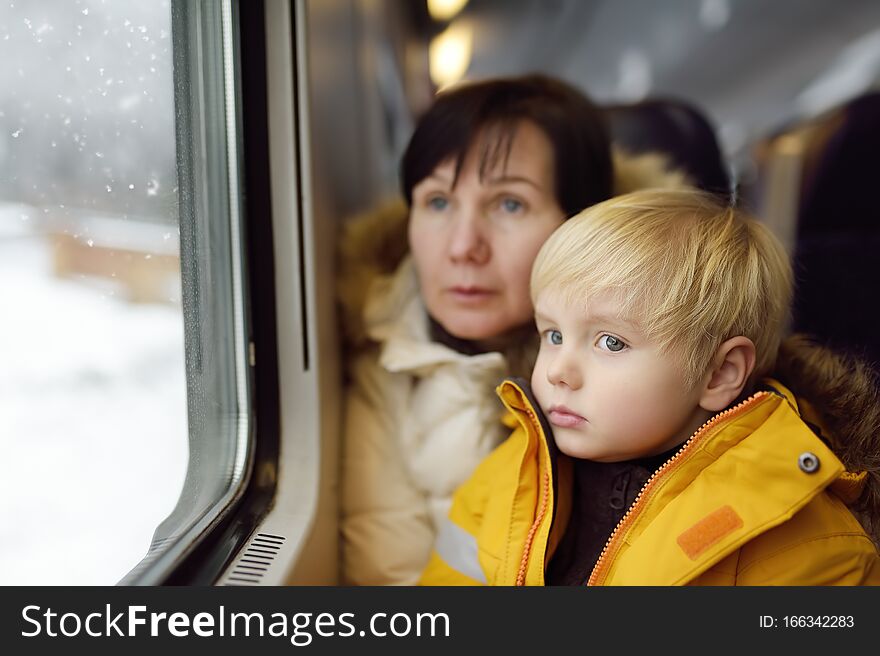 Family looking out of the window of train during travel on cogwheel railway/rack railway in Alps mountains. Winter holidays in Swiss/German/Italian Alps