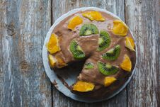 Homemade Sponge Cake With Chocolate Cacao Ganache Frosting. Slices Of Kiwi And Orange On The Dessert. Baked Pastry In The Kitchen Royalty Free Stock Photos
