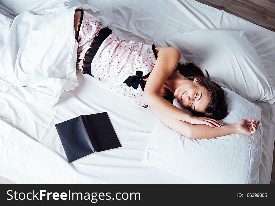 Girl in pajamas lying on the bed with a book before bed 1