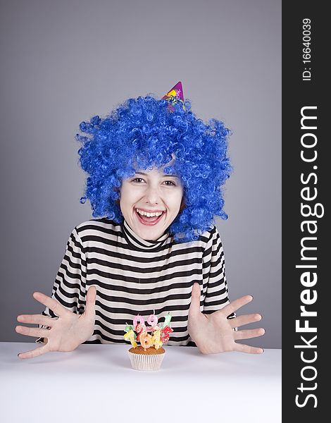 Funny blue-hair girl with cake. Studio shot.