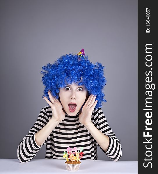 Funny blue-hair girl with cake. Studio shot.