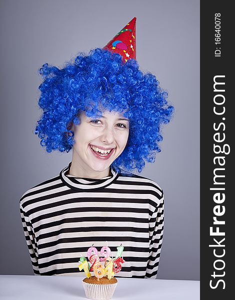 Funny blue-hair girl with cake. Studio shot.