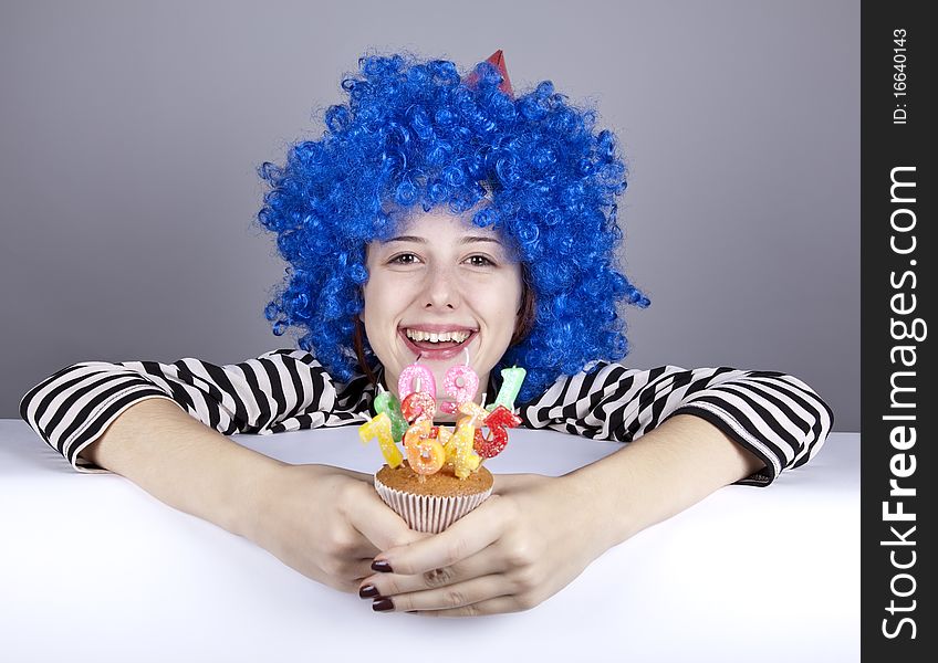 Funny blue-hair girl with cake. Studio shot.