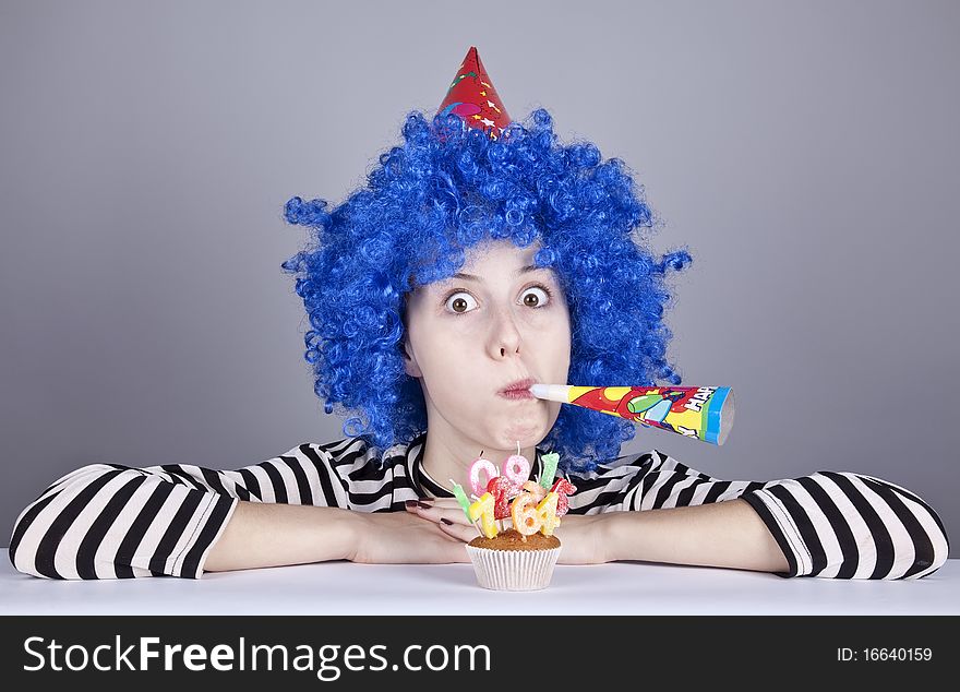 Funny blue-hair girl with cake. Studio shot.