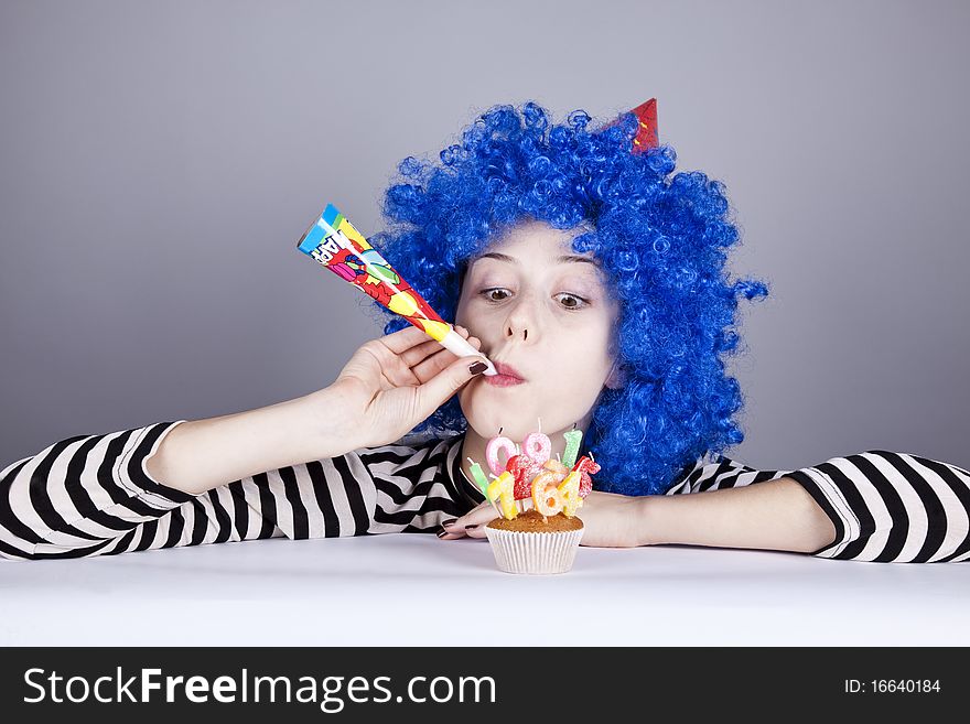 Funny blue-hair girl with cake. Studio shot.