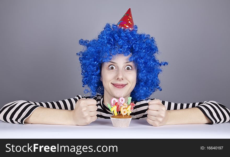 Funny blue-hair girl with cake. Studio shot.
