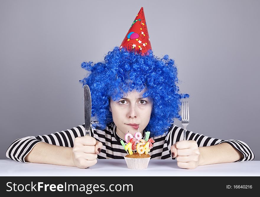 Funny blue-hair girl with cake. Studio shot.