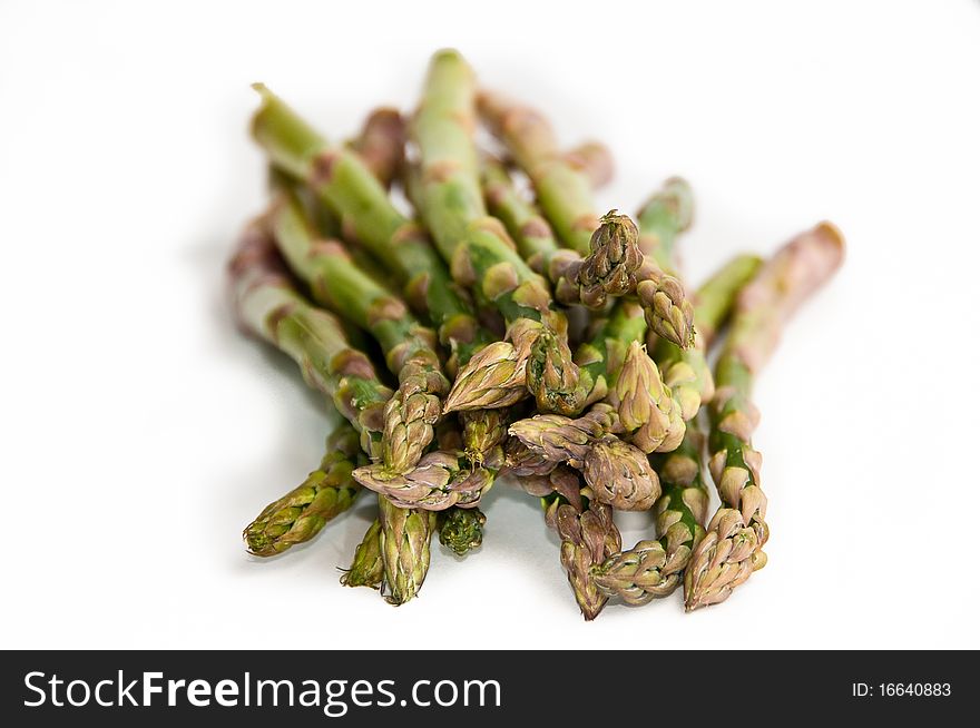 A close-up of a bunch of fresh, green asparagus with shalow depth of field on white background. A close-up of a bunch of fresh, green asparagus with shalow depth of field on white background