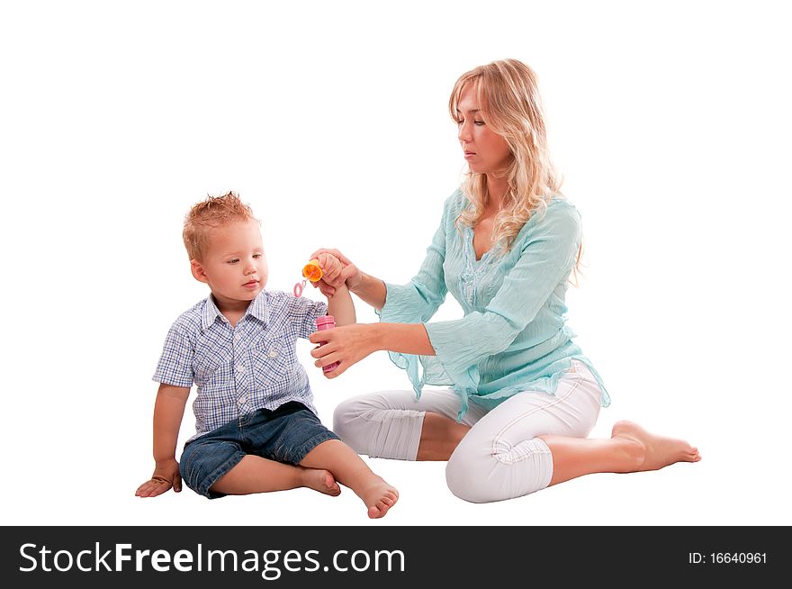 Mother With Joyful Son Playing With Soap Bubbl