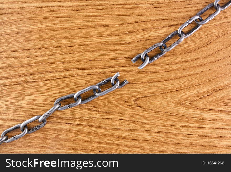 Broken chain over wood texture background