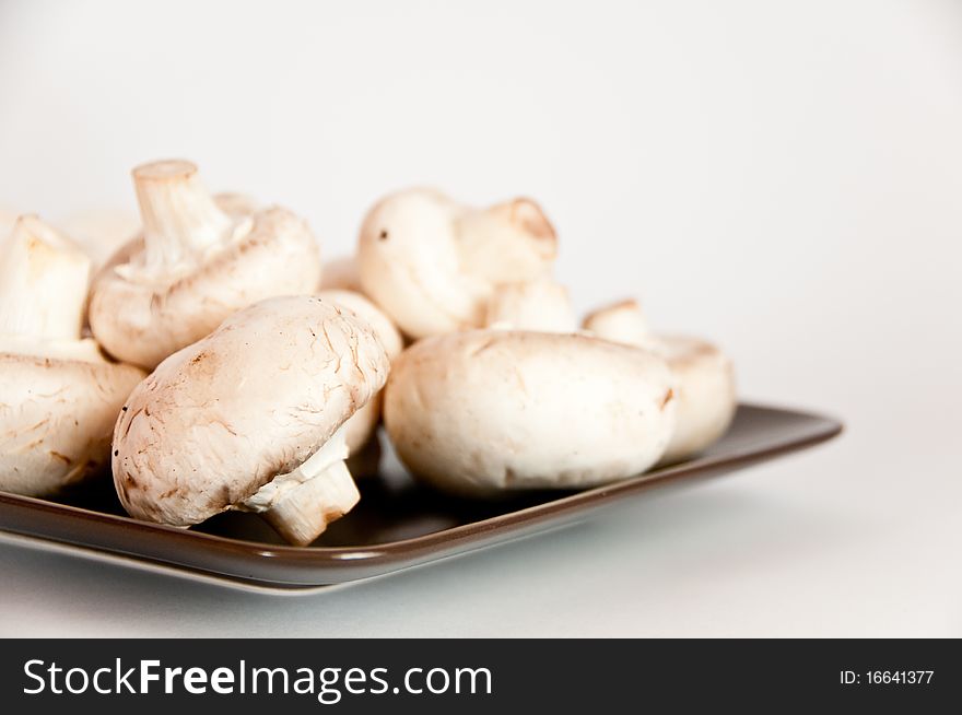 Close up of white mushroom on a brown plate with isolating background