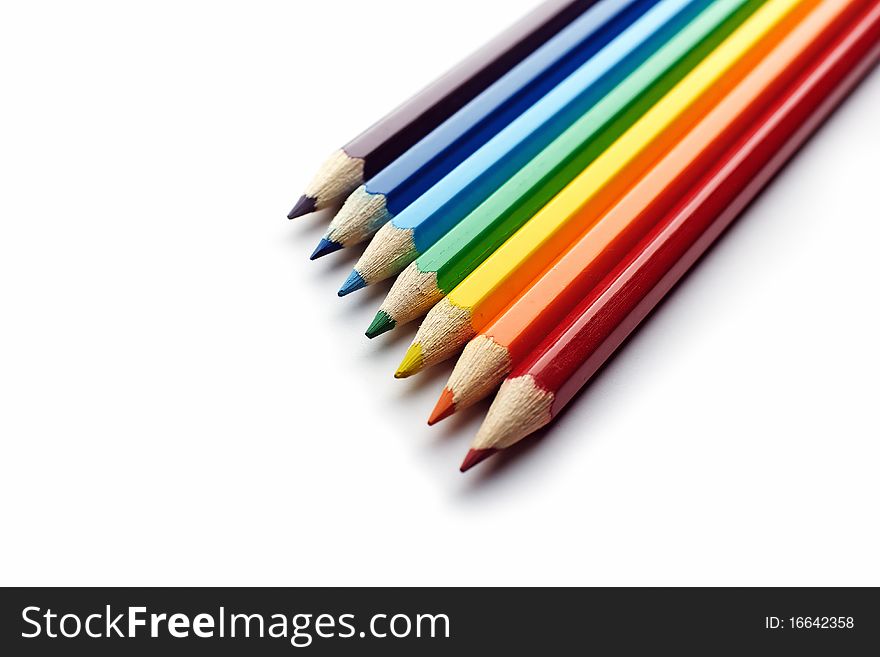 Colored pencils arranged in rainbow spectrum order isolated on white background