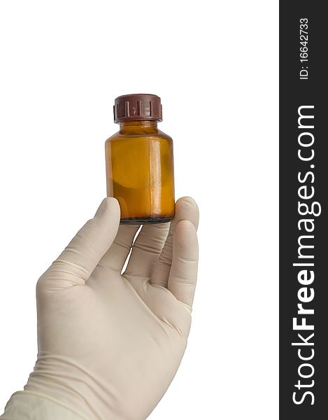 The hand in a glove on the isolated background holds a medicine