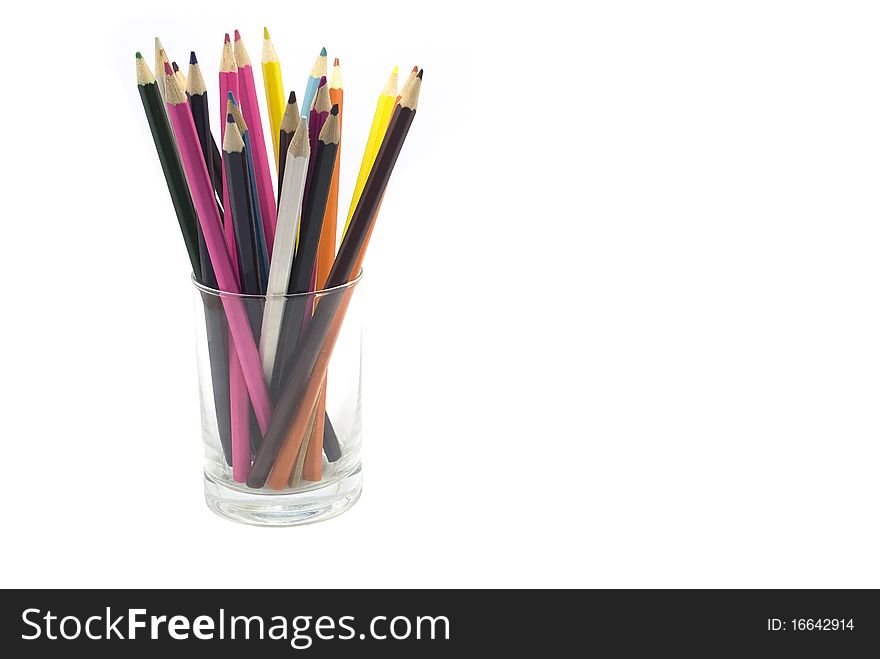 Some colour pencils in a transparent glass