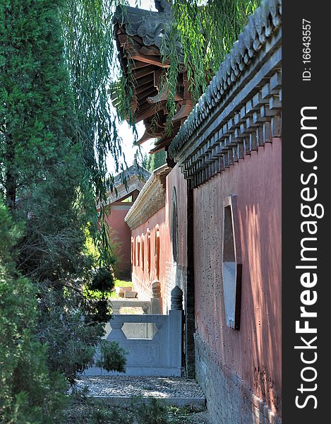 Garden corner view in Chinese traditional style, shown as featured wall and window in green trees shadow. Garden corner view in Chinese traditional style, shown as featured wall and window in green trees shadow.