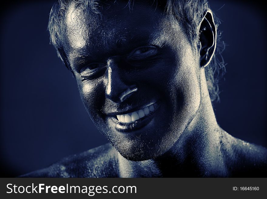 Portrait of expressive man painted with black color. Body painting project. Portrait of expressive man painted with black color. Body painting project.