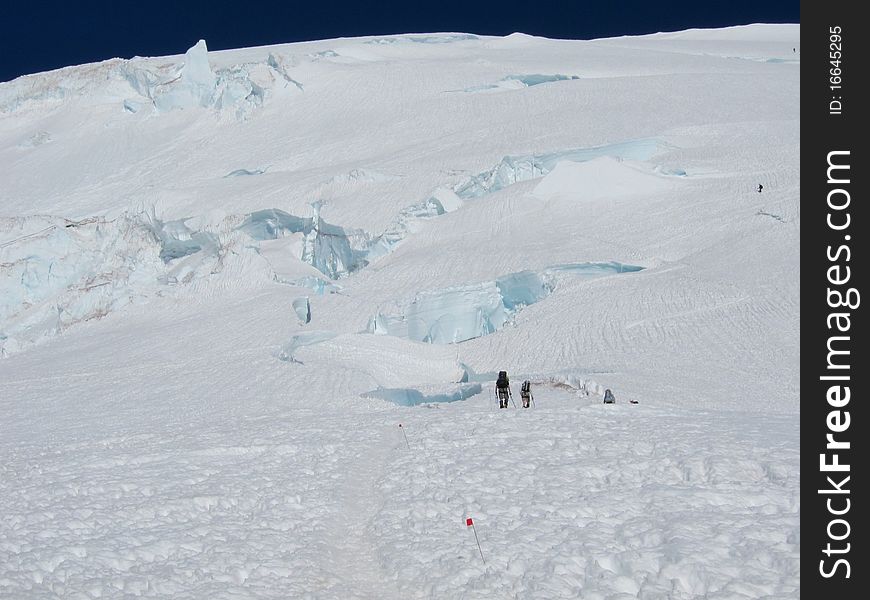 Climbers making their way toward the summit of Mount Rainier. Disappointment Cleaver route, above the cleaver at 12,300 ft. Climbers making their way toward the summit of Mount Rainier. Disappointment Cleaver route, above the cleaver at 12,300 ft.