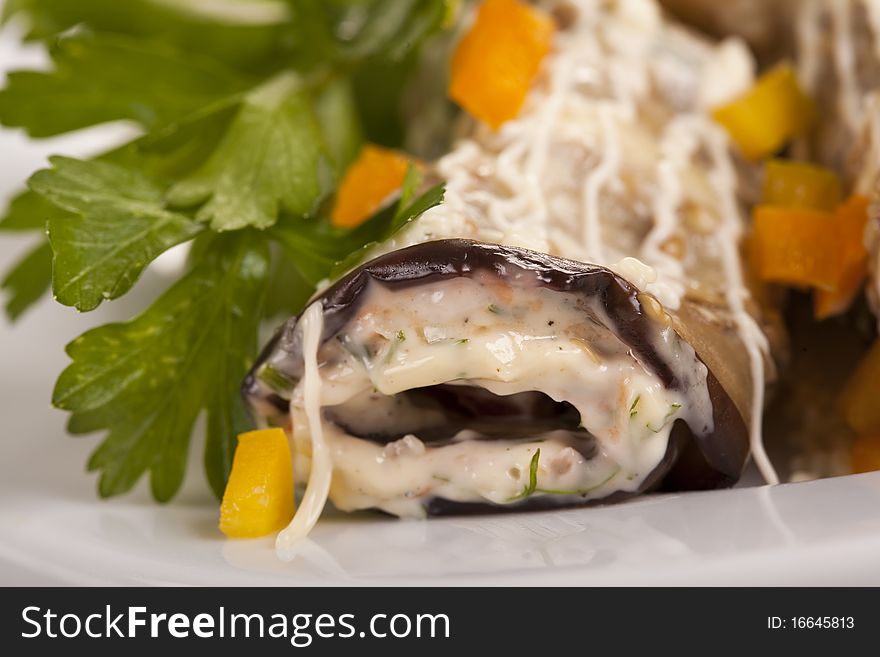 Baked Eggplant rolls stuffed Tomato and Dressed with Parsley. Over white background