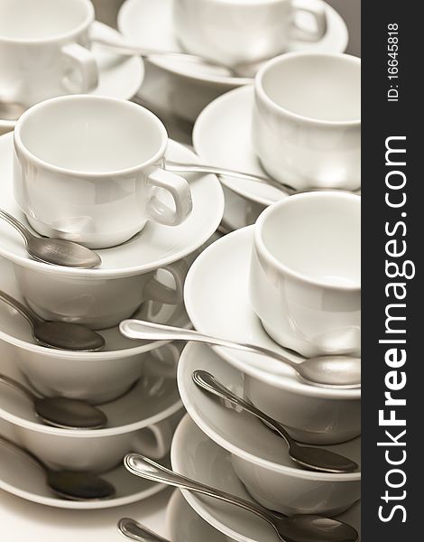 Stacked empty teacups with teaspoons