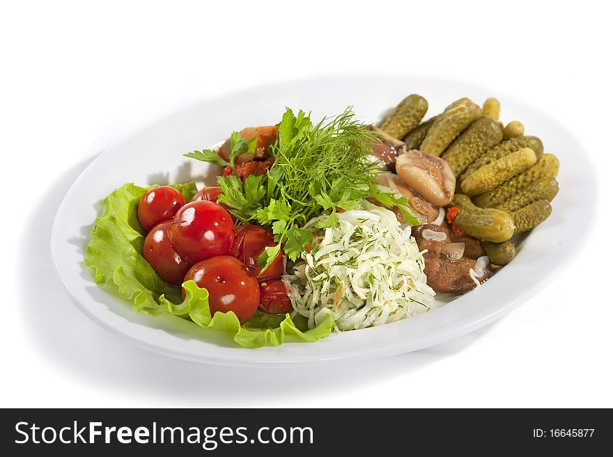 Marinated vegetables and mushrooms at the plate isolated on a white background