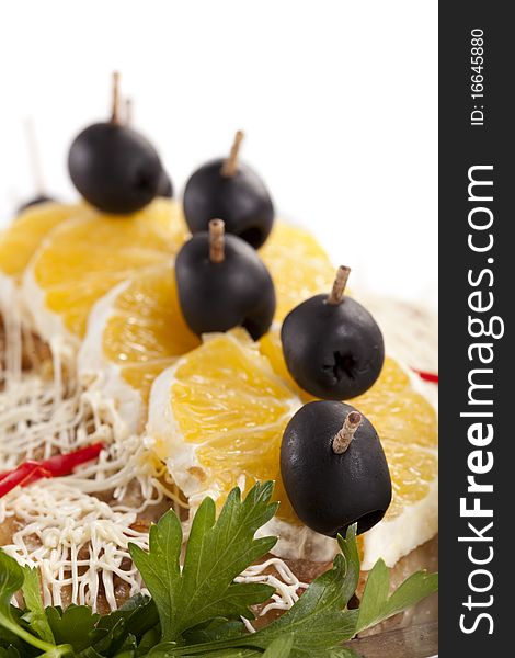 Chicken gratin  covered with  orange slices and olives on skewers. Chicken gratin  covered with  orange slices and olives on skewers