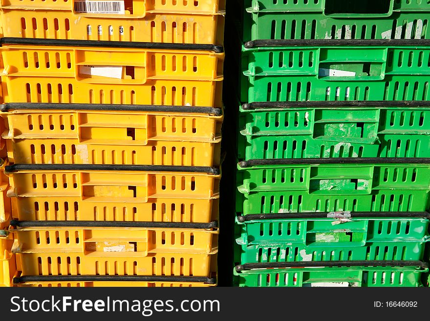 Plastic storage containers in yellow and green stacks. Plastic storage containers in yellow and green stacks.