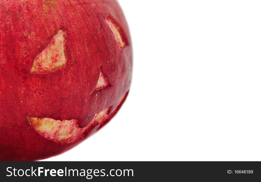 Halloween face cut out on fruit. Isolated on white