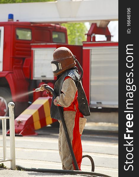 Worker in a protective suit spraying sand  with abrasive peeler