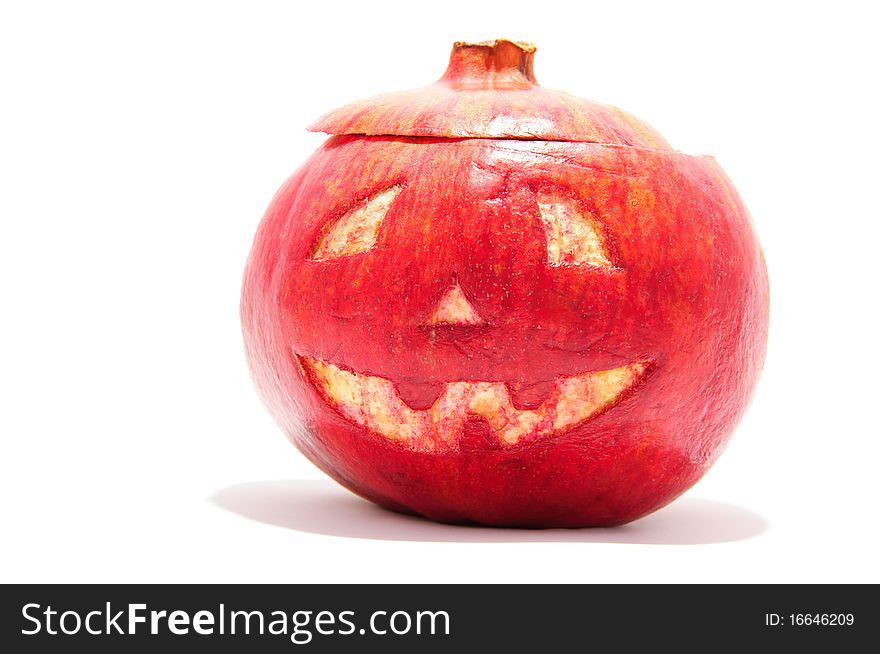Halloween face cut out on fruit. Isolated on white