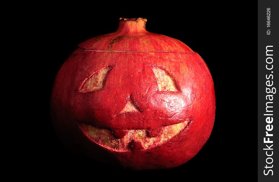 Halloween face cut out on fruit. Isolated on black. Halloween face cut out on fruit. Isolated on black