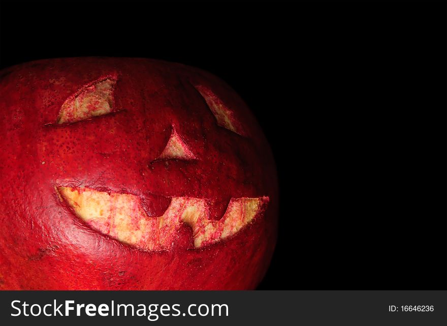 Halloween face cut out on fruit. Isolated on black. Halloween face cut out on fruit. Isolated on black