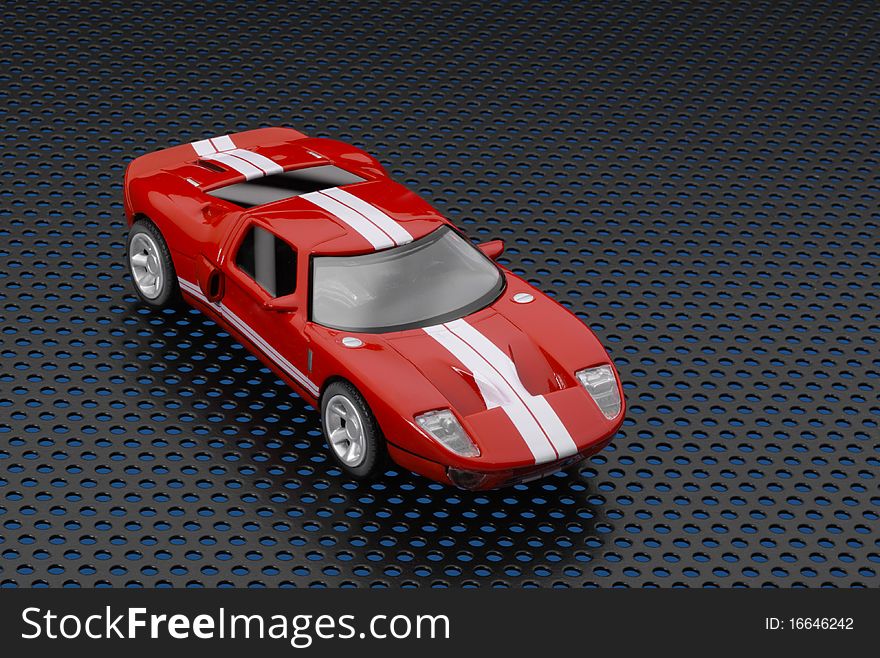 Red toy Ford GT with logos removed on black  metal background. Red toy Ford GT with logos removed on black  metal background.