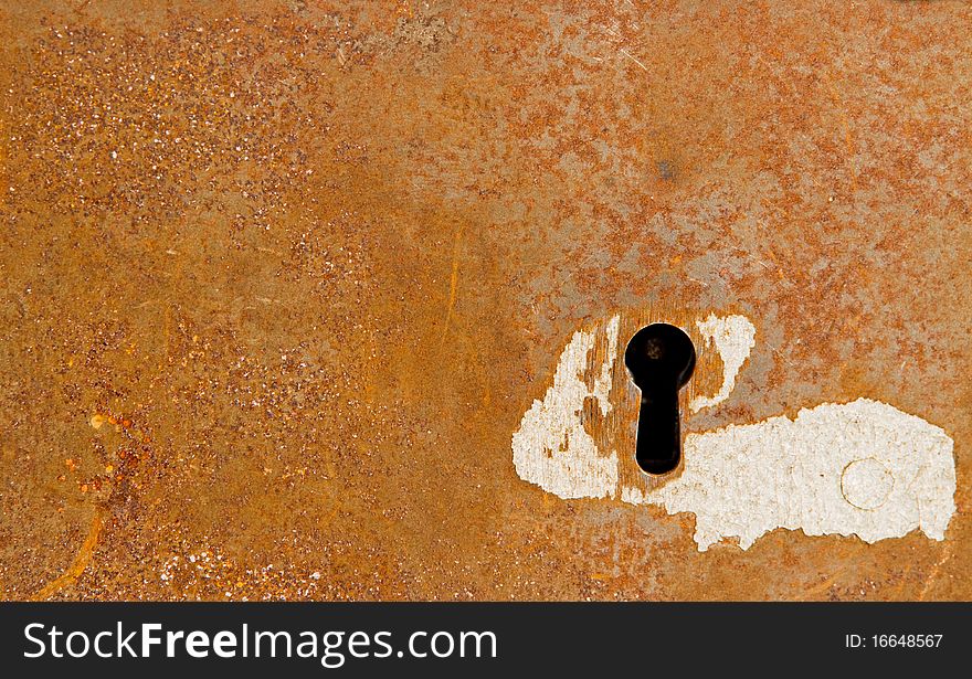 Close-up of a keyhole in a rusty background