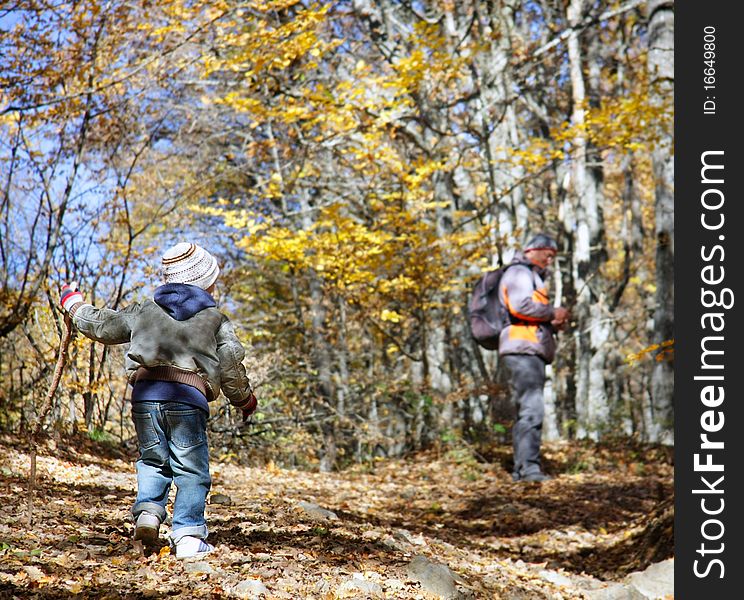 Father and son in autumn forest