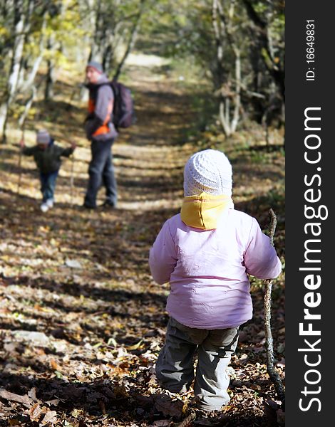 Father and two kids in autumn forest