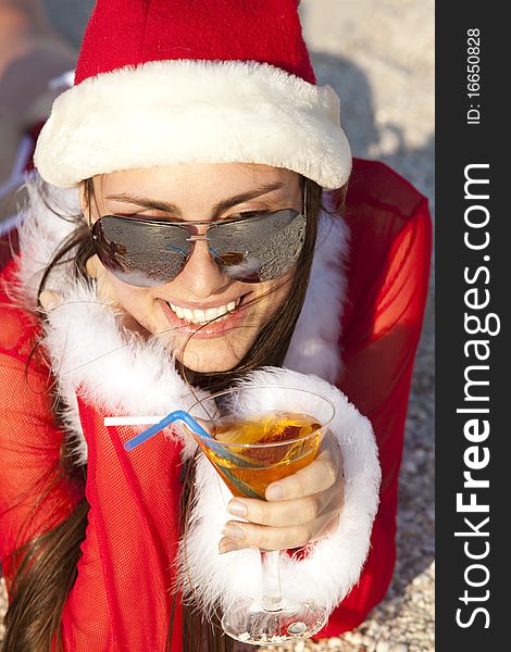 Young beautiful woman in christmas suit with martini glass on the beachfront. Young beautiful woman in christmas suit with martini glass on the beachfront