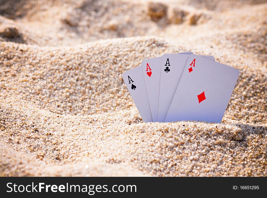 The four Aces dispayed in the sand on a beach. The four Aces dispayed in the sand on a beach.