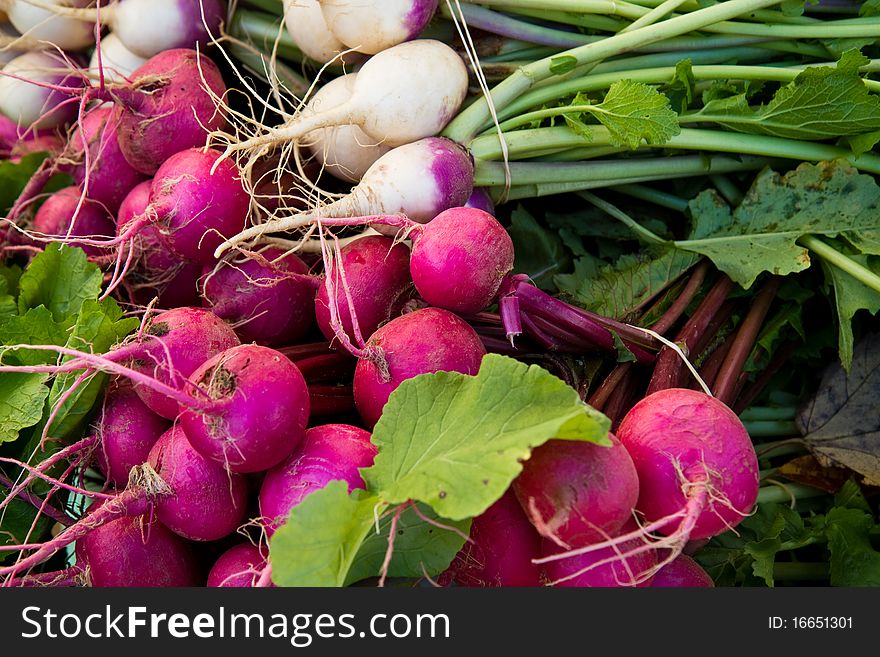 Crimson and white turnips on display at a farmer's market